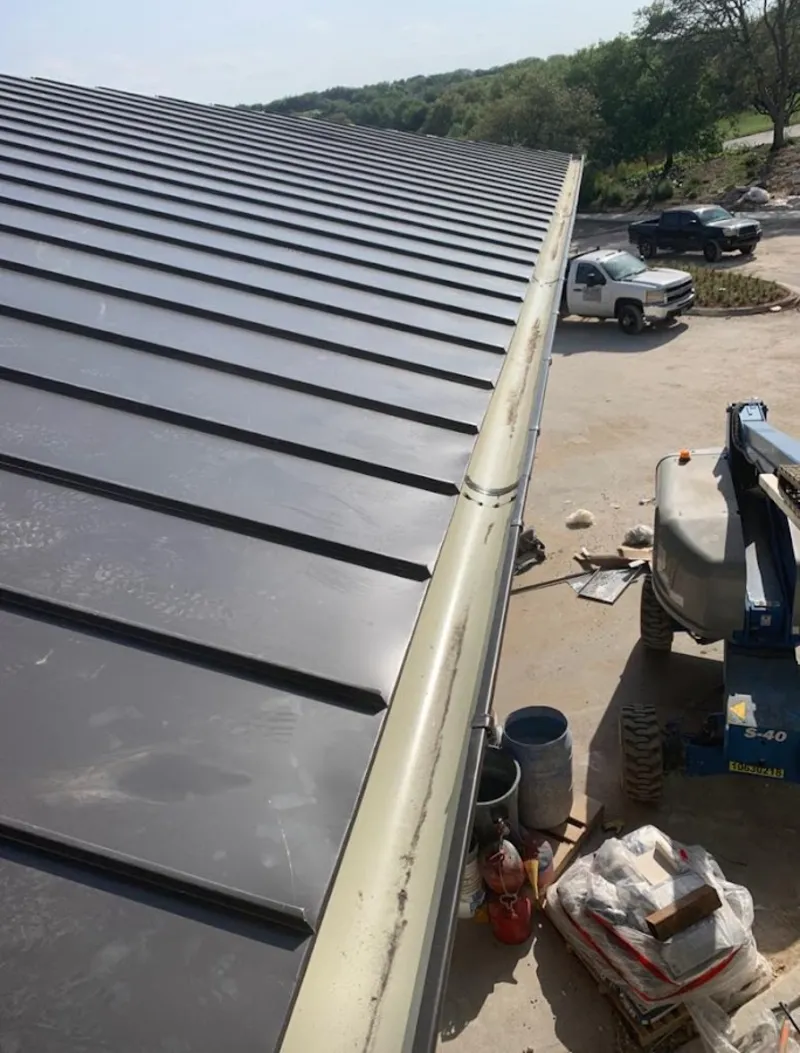Standing seam panel and gutter detail on a metal roofing jobsite in Glasgow